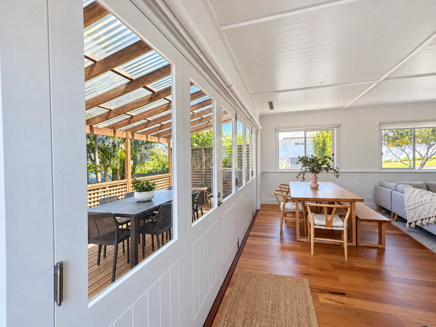 Sunroom looking out to a timber pergola and outdoor table