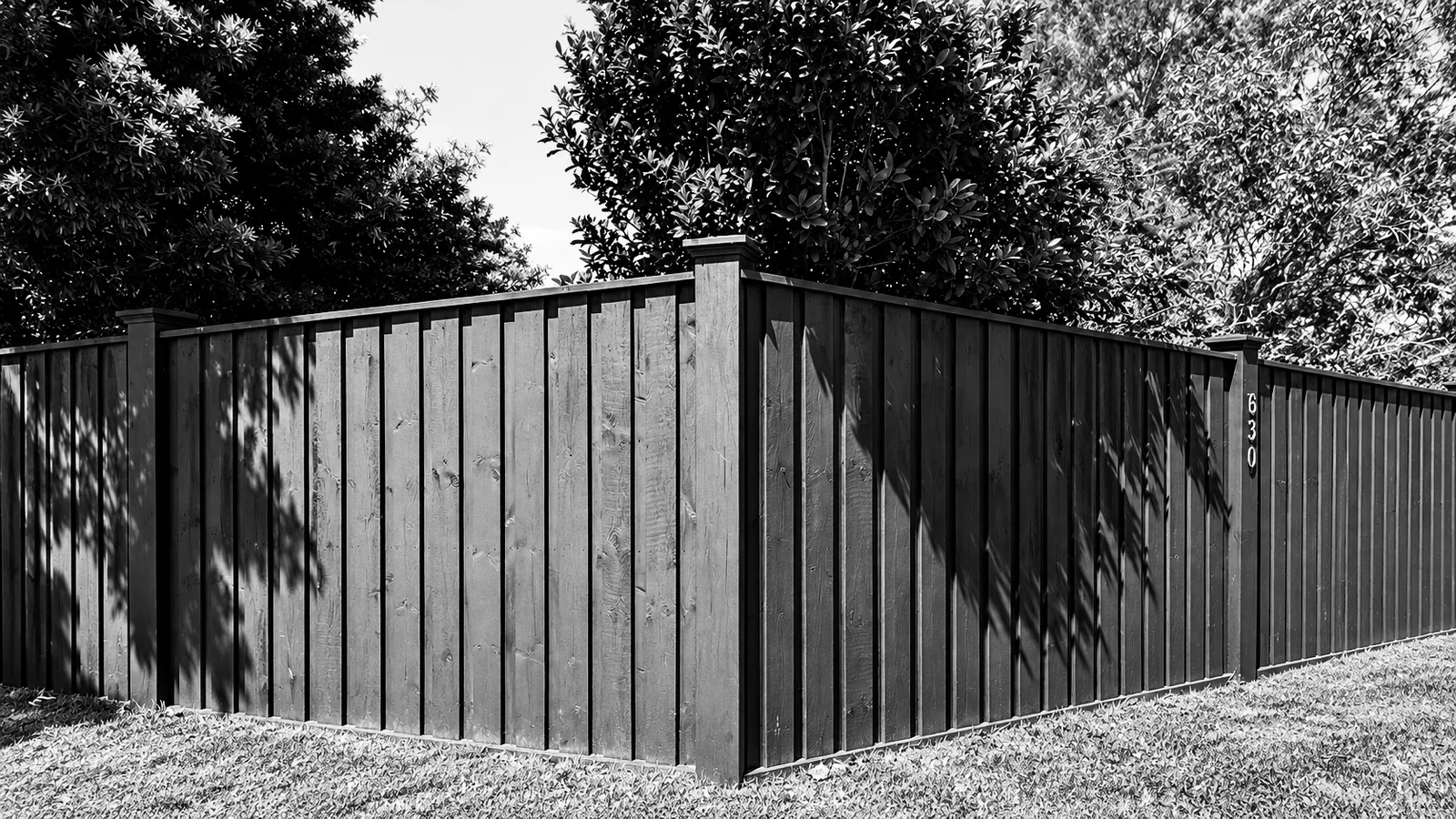 Black timber boundary fence, black and white
