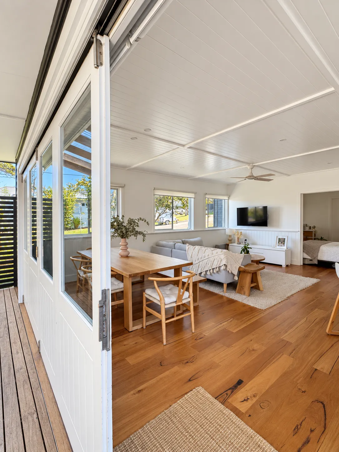 Open living and dining space with timber floor and sliding doors