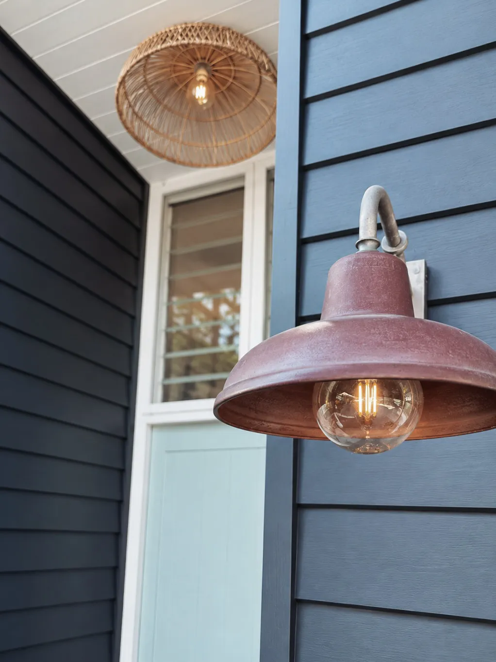 Barn light and cane pendant against black cladding