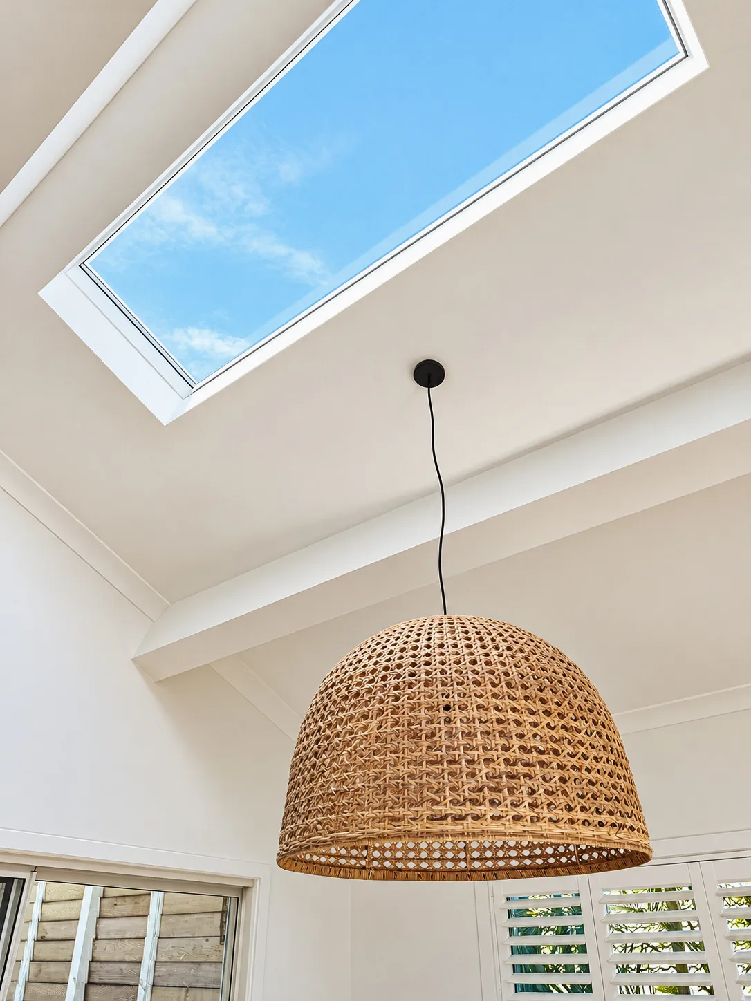 Skylight above a woven pendant light in the upstairs hall