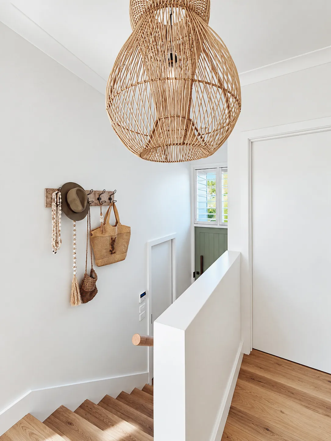 Staircase with a cane pendant light and white balustrade