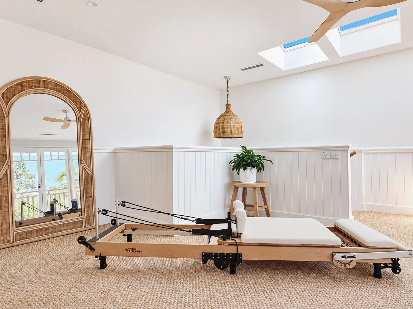 Upstairs studio with arched cane mirror, skylights and pendant light