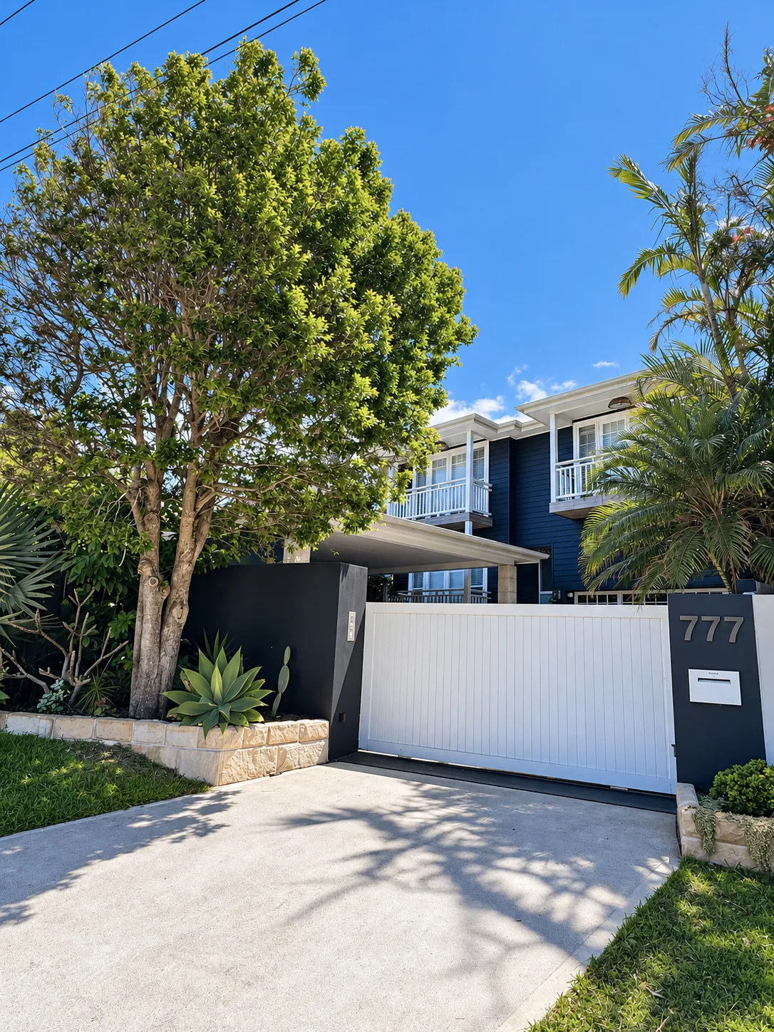 Front fence and white gate with house number, black house behind