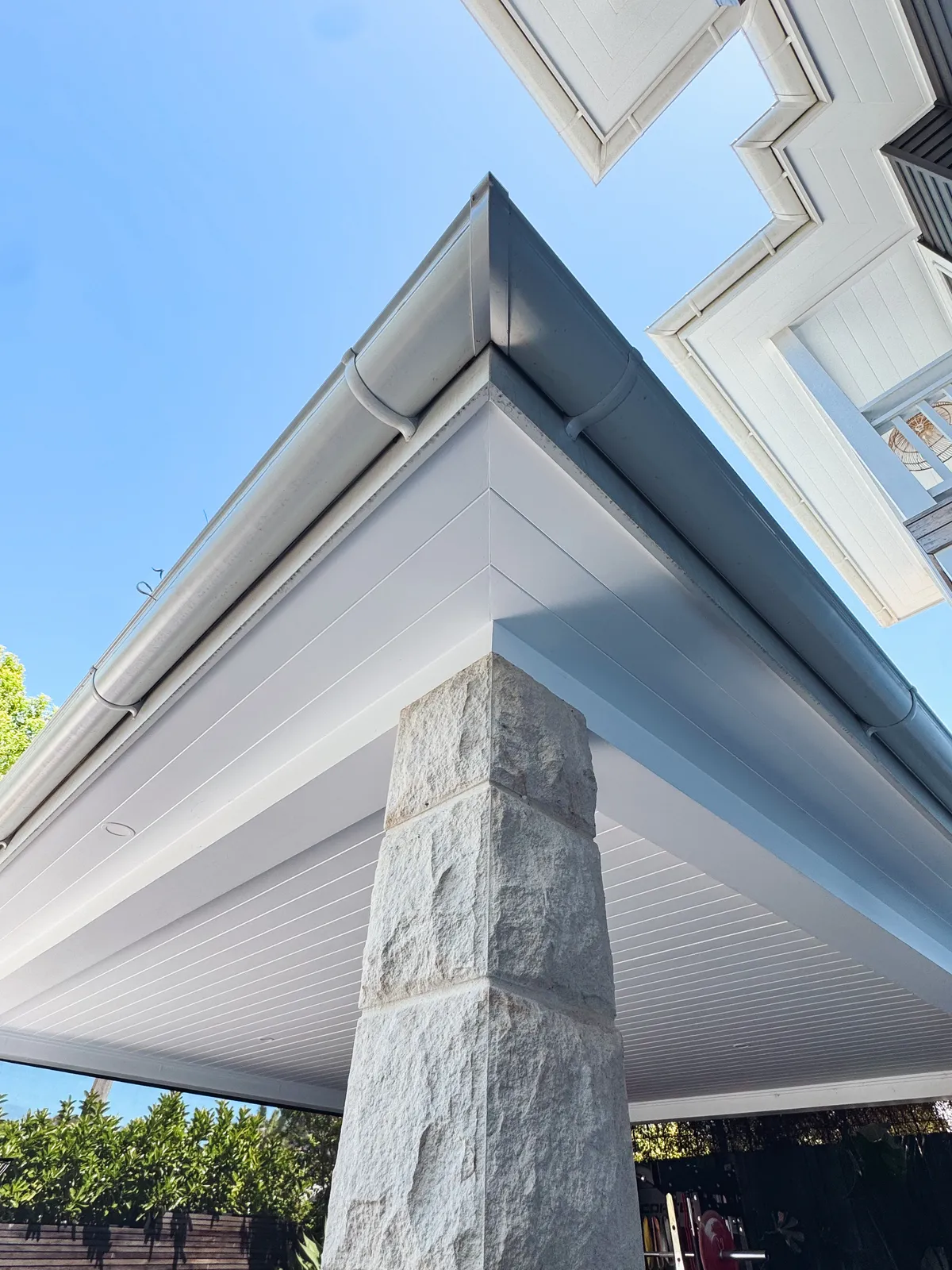 Sandstone column under a carport with a white soffit