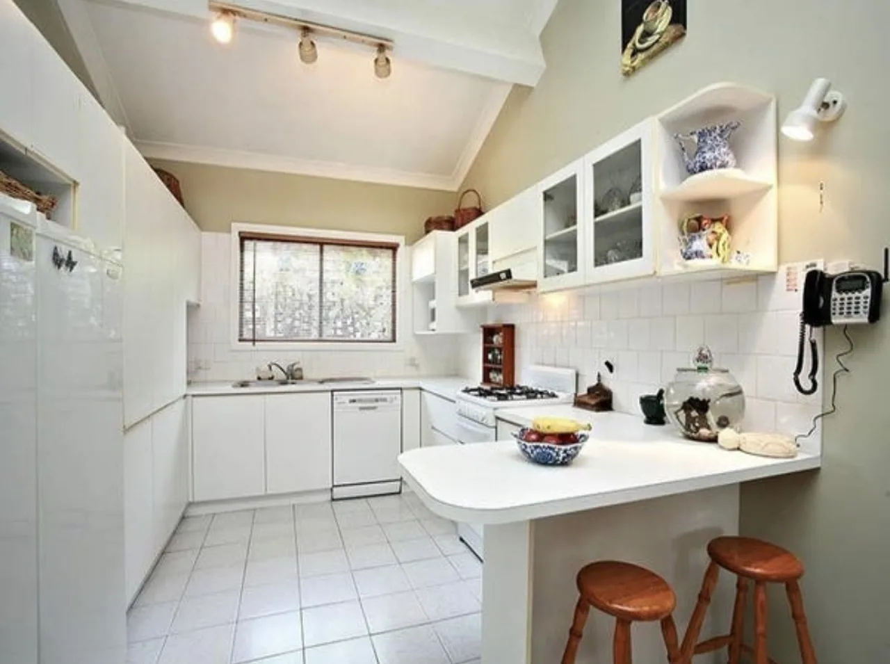 Avalon kitchen before: white laminate cabinets, tiled floor and splashback