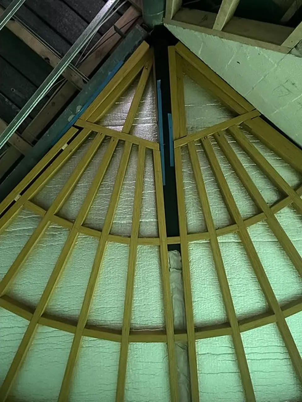 Curved roof framing with insulation between the rafters