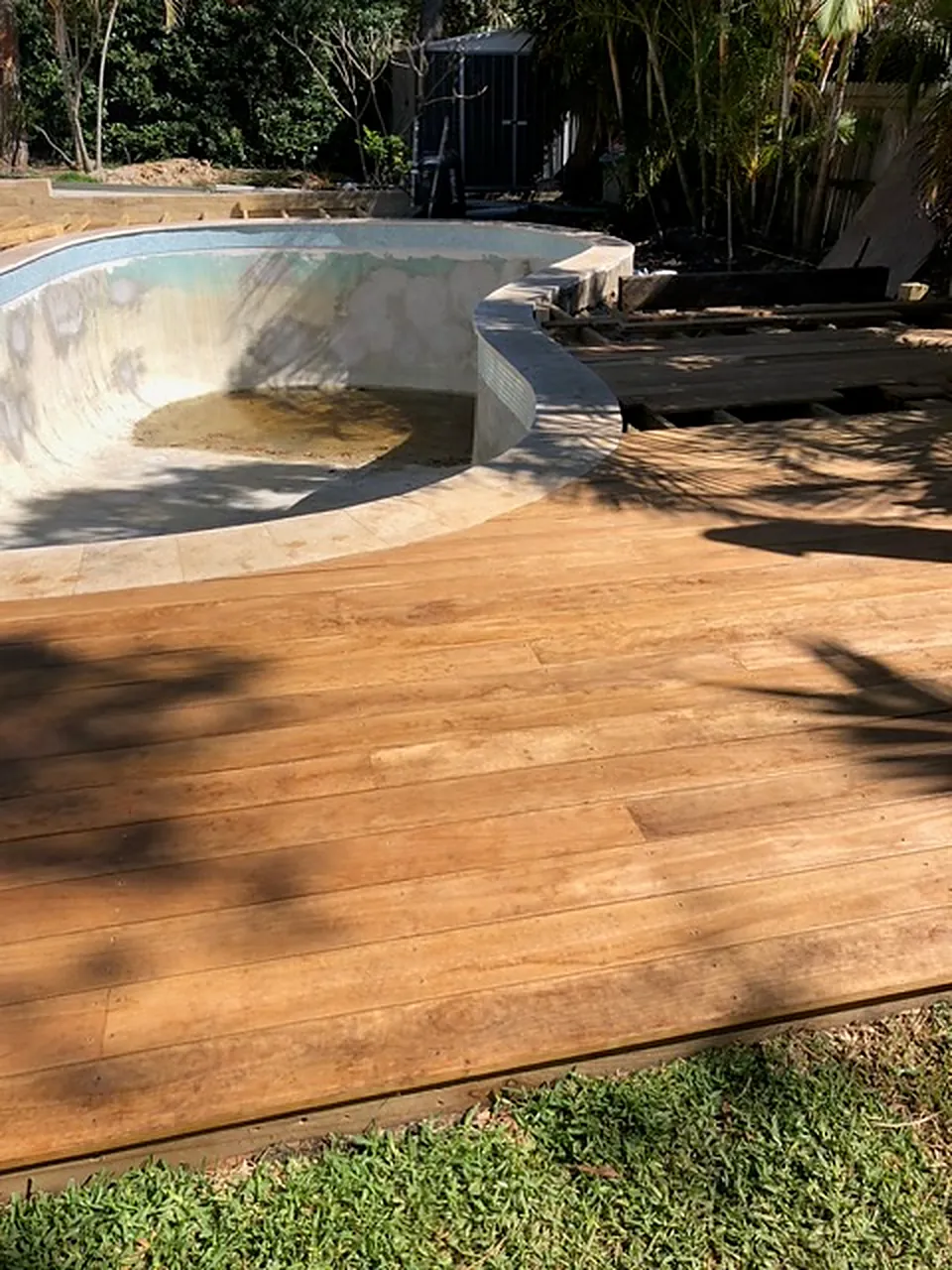 New hardwood deck laid around a pool during the build